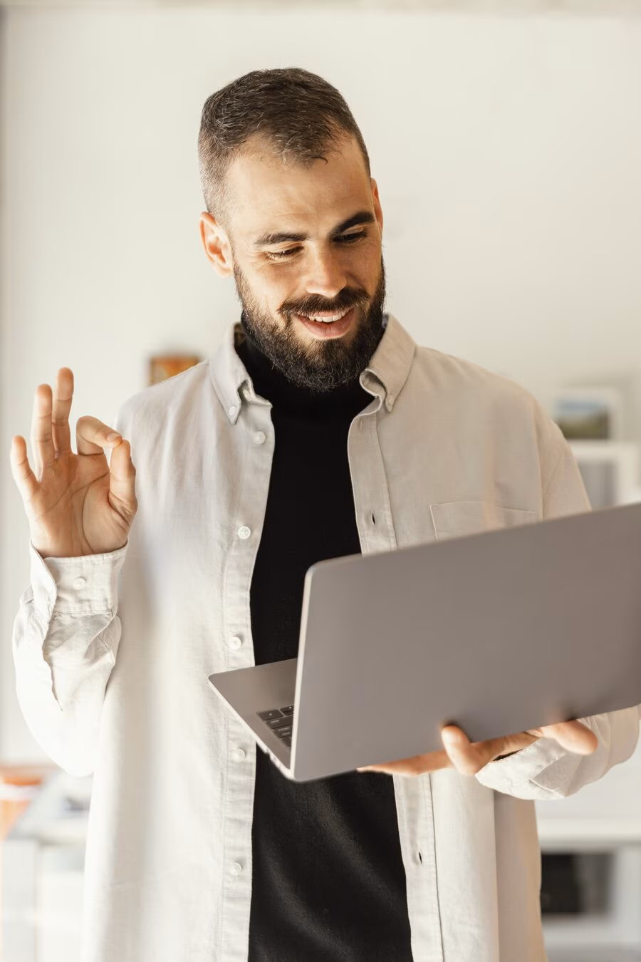 A colleague smiles while working on a laptop